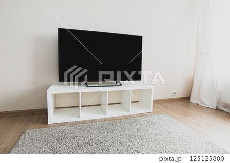 Lcd tv on white shef at modern room interior Lcd tv on white shef at modern room interior 125125800