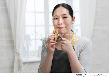 キッチンで米粉のパウンドケーキを作る女性 キッチンで米粉のパウンドケーキを作る女性 125127425