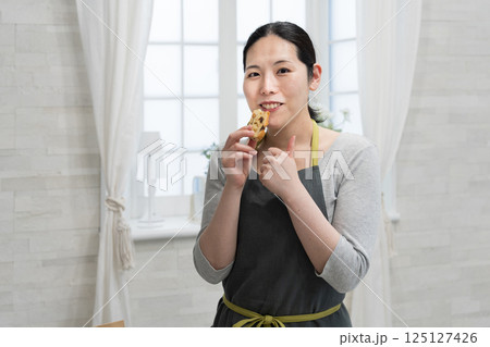 キッチンで米粉のパウンドケーキを作る女性 キッチンで米粉のパウンドケーキを作る女性 125127426