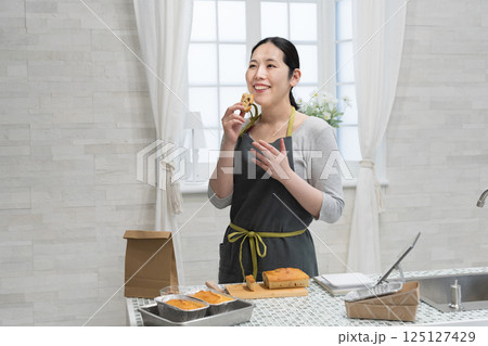 キッチンでパウンドケーキを作る女性 キッチンでパウンドケーキを作る女性 125127429