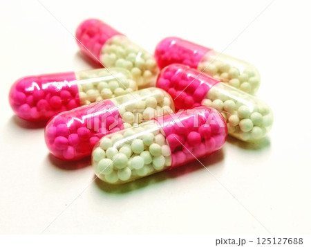 A picture of red and white capsules isolated on white background 125127688