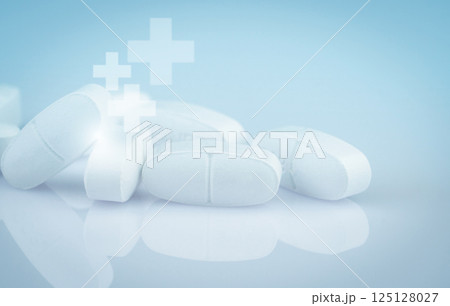 Pile of white antibiotic tablets on smooth gradient background. Pharmaceutical industry. Medical and healthcare. Medication treatment options and drug resistance concerns. White pharmaceutical pills. 125128027