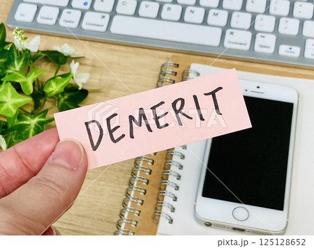 デメリットと書かれた付箋を持つ手元 デメリットと書かれた付箋を持つ手元 125128652