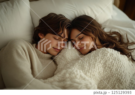 Close up of a young loving heterosexual couple sweet sleeping embracing each other. In a close-up shot, the couple sleeps peacefully, their embrace reflecting the warmth of their love. 125129393
