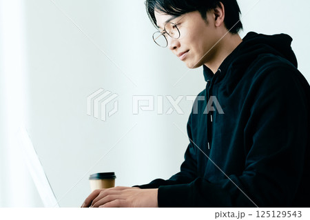 パソコン作業をする若い男性 125129543