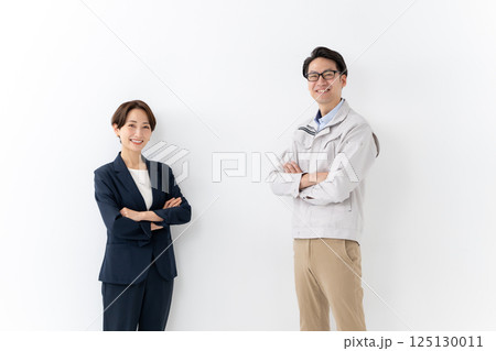 スーツ女性と作業着男性のビジネスイメージ 125130011