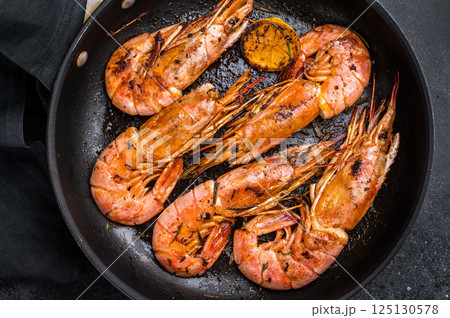 Pan fried red Argentine shrimps, Prawns Langostino Austral with herbs. black background. top view 125130578