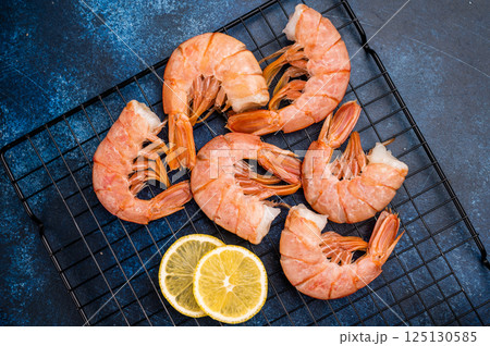 Ready for cooking Headless Red shrimps, raw Prawns on a rack. blue background. top view Ready for cooking Headless Red shrimps, raw Prawns on a rack. blue background. top view 125130585