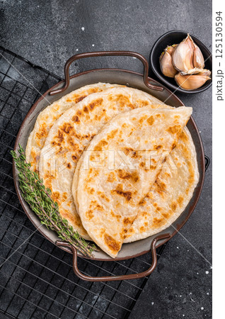 Aloo Paratha Indian Potato stuffed Flatbread. black background. top view Aloo Paratha Indian Potato stuffed Flatbread. black background. top view 125130594