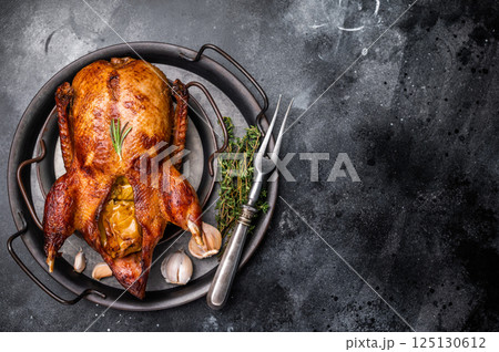 Roasted whole goose on steel tray. black background. top view 125130612