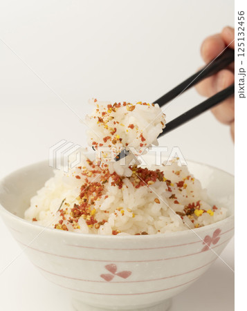 肉そぼろと海苔のふりかけをかけた温かいご飯を箸で持ち上げる 125132456