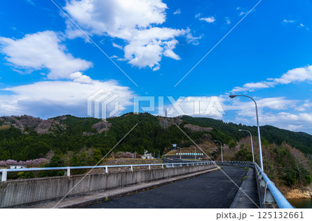 桜の季節の布目ダム 堰堤上のアスファルト道路と晴れ渡った空に浮かぶわた雲① 桜の季節の布目ダム 堰堤上のアスファルト道路と晴れ渡った空に浮かぶわた雲① 125132661