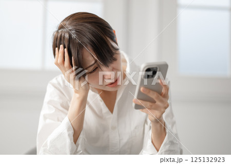 スマートフォンを見て驚く女性 スマートフォンを見て驚く女性 125132923