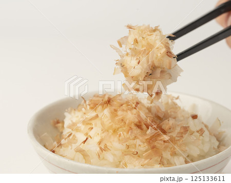 かつお節をかけた温かいご飯を箸で持ち上げる 125133611