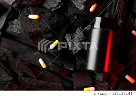 Black plastic jar and pills on dark background, space for text 125135141