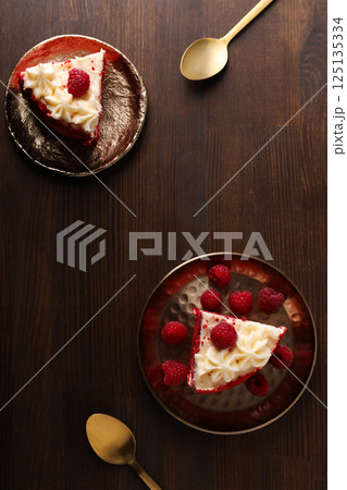 Pieces of red velvet cake on plates on wooden background, top view 125135334