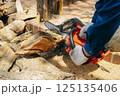 チェーンソーで木材を切断する様子 125135406
