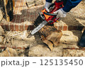 チェーンソーで材木を切断する様子 125135450