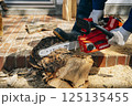 チェーンソーで材木を切断する様子 125135455