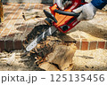 チェーンソーで材木を切断する様子 125135456