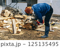 チェーンソーで材木を切断する様子 125135495