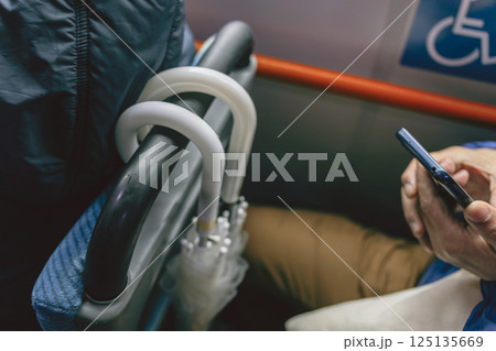 バスの中 立てかけたビニール傘 スマートフォンを見る手 スナップ写真 バスの中 立てかけたビニール傘 スマートフォンを見る手 スナップ写真 125135669