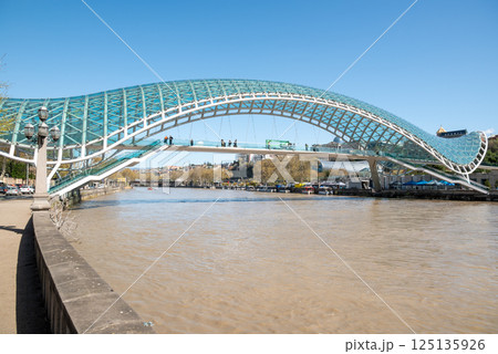 Peace bridge, steel and glass construction pedestrian bridge over Kura Mtkvari river in central Tbilisi, Georgia 125135926
