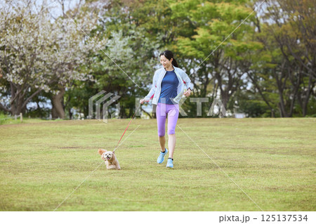 愛犬とジョギングを楽しむ女性 愛犬とジョギングを楽しむ女性 125137534