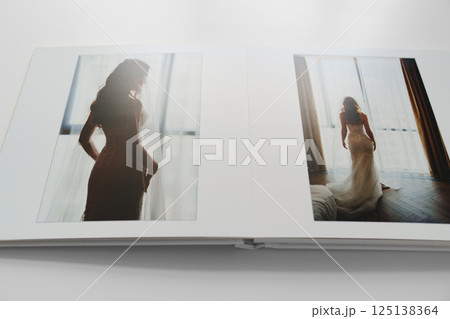 the pages of a photo book with wedding photos.  125138364