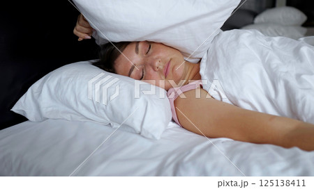Irritated woman lies in bed suffering from insomnia Irritated woman lies in bed suffering from insomnia 125138411