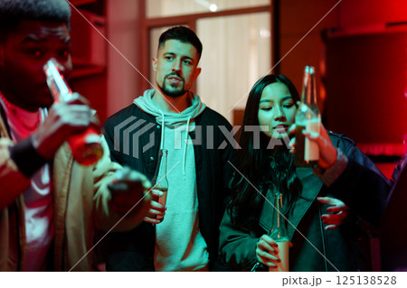 Friends enjoying drinks together in an urban setting during a vibrant evening gathering 125138528