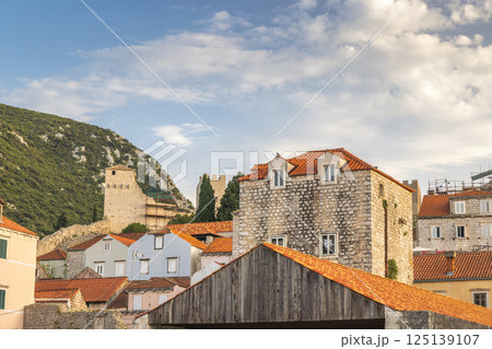 Mali Ston, village in Peljesac peninsula in Croatia, Europe. Picturesque European townscape with historic buildings, red roofs, and distant mountain backdrop. Classic European scenery. Mali Ston, village in Peljesac peninsula in Croatia, Europe. Picturesque European townscape with historic buildings, red roofs, and distant mountain backdrop. Classic European scenery. 125139107