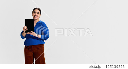 Smiling woman, university instructor holding digital tablet, symbolizing openness, enthusiasm and tech-friendly attitude during online education 125139223