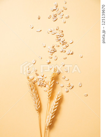 Oat flakes with wheat scattered on a yellow background. Healthy eating and wholesome diet breakfast Oat flakes with wheat scattered on a yellow background. Healthy eating and wholesome diet breakfast 125139670