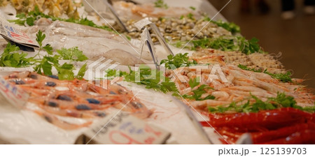 Fresh seafood displayed on ice at a market, featuring shrimp, squid, and other delicacies Fresh seafood displayed on ice at a market, featuring shrimp, squid, and other delicacies 125139703
