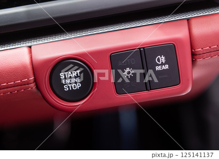 Car dashboard with focus on engine start stop button Car dashboard with focus on engine start stop button 125141137