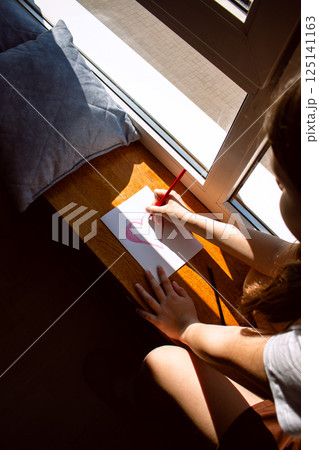 Daughter creating personalized card for mom's birthday, 8 march, mother's day. Children love. Parenthood topic. 125141163