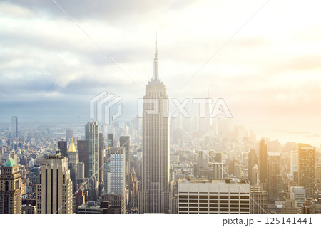 Sunset view of Manhattan skyline bathed in warm golden light and surrounded by glowing skyscrapers Sunset view of Manhattan skyline bathed in warm golden light and surrounded by glowing skyscrapers 125141441