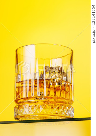 A classic whiskey glass filled with golden amber whiskey 125141554