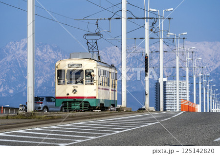 立山連峰を背景に富山大橋を渡る富山地方鉄道の市内電車 立山連峰を背景に富山大橋を渡る富山地方鉄道の市内電車 125142820