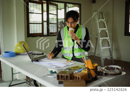 Architect or site supervisor checking project details at work table 125142826