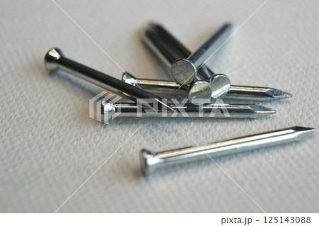 Close-up of small metal nails on a white background 125143088