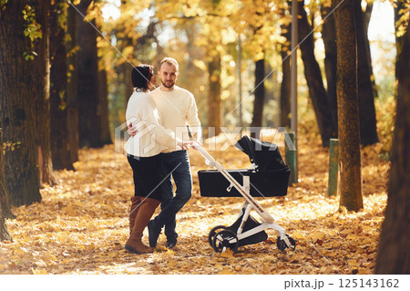 Beautiful parents is in the forest with pram having a walk Beautiful parents is in the forest with pram having a walk 125143162