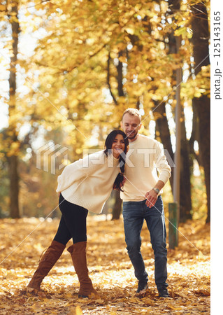 Beautiful couple standing in the autumn park at daytime 125143165