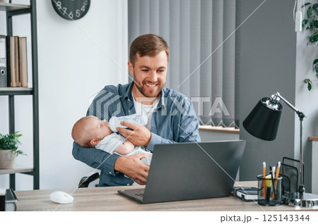 Father with toddler is indoors in the office 125143344