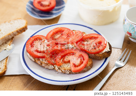 Two bruschettas with tomato slices on a plate 125143493