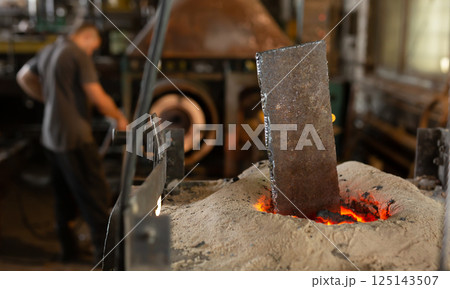 Foundry ferrous metal is melted in an induction furnace of metallurgical plant Foundry ferrous metal is melted in an induction furnace of metallurgical plant 125143507