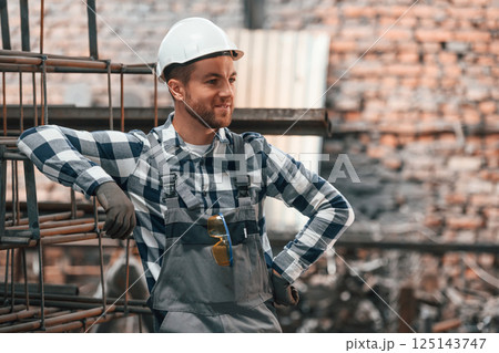 Friendly factory male worker in uniform is indoors 125143747