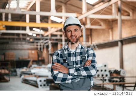 Beautiful portrait. Factory male worker in uniform is indoors Beautiful portrait. Factory male worker in uniform is indoors 125144013