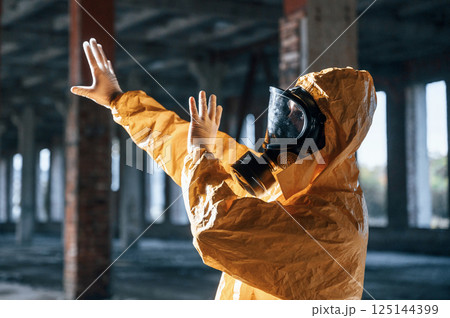 Nuclear explosion. Man dressed in chemical protection suit in the ruins of the post apocalyptic building 125144399